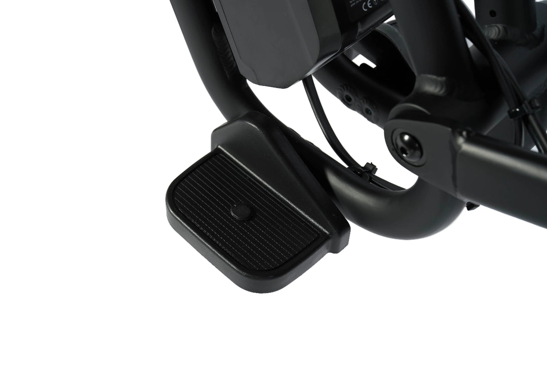 Close-up of a black motorcycle foot peg on a white background