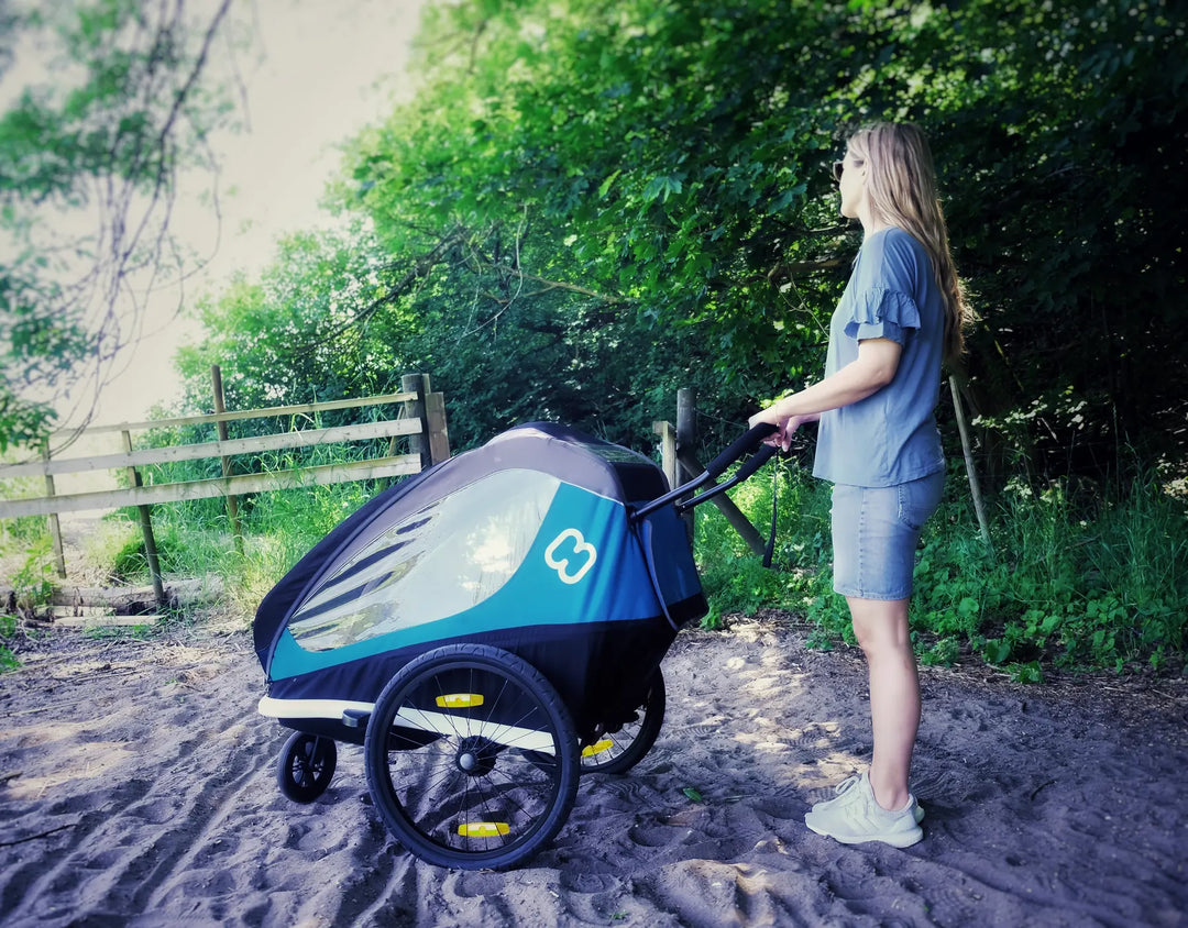 Side view of the Hamax Traveller stroller on a shaded path